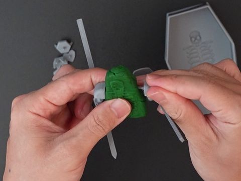 ねんどの胴体にうでパーツの軸を挿しているところ