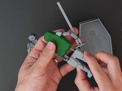 ねんどの胴体にあしパーツを挿しているところ