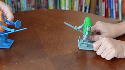 操作棒を持って人形を動かし、打ち合っているところ