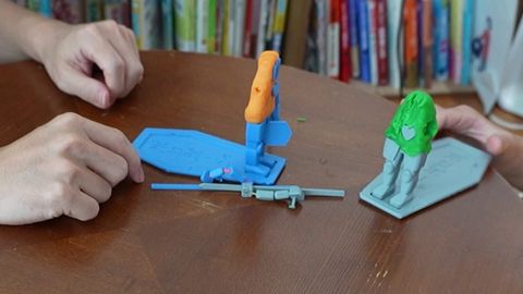 テーブルに外れたパーツが散らばり、2体がにらみ合っているところ